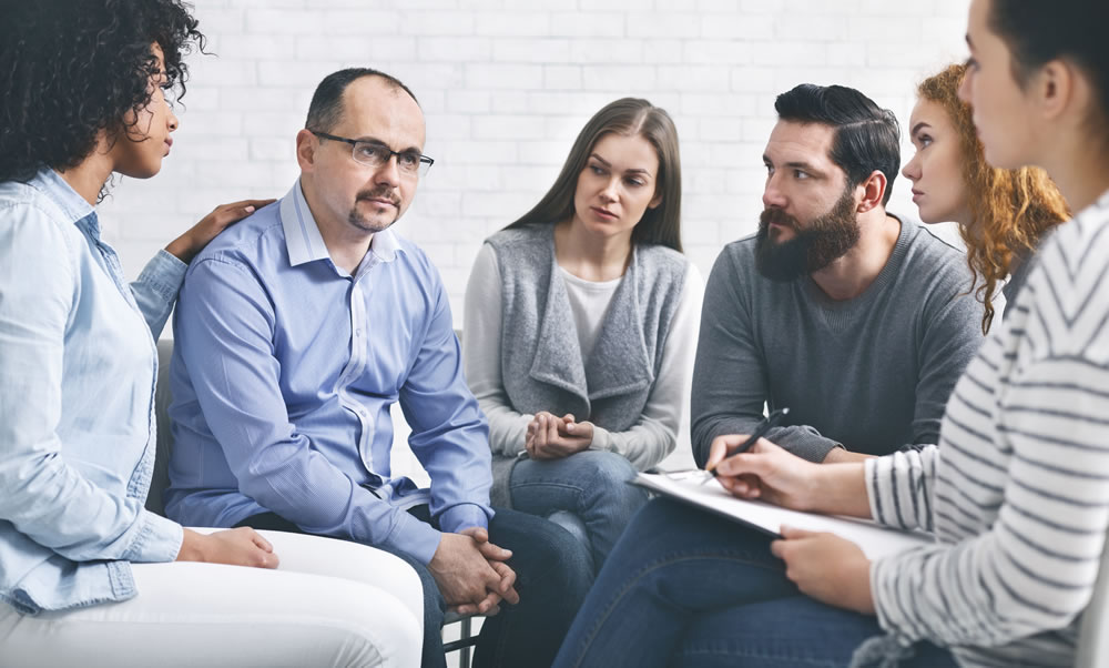 man receives family support with aid of New Life Recovery Center team in white background
